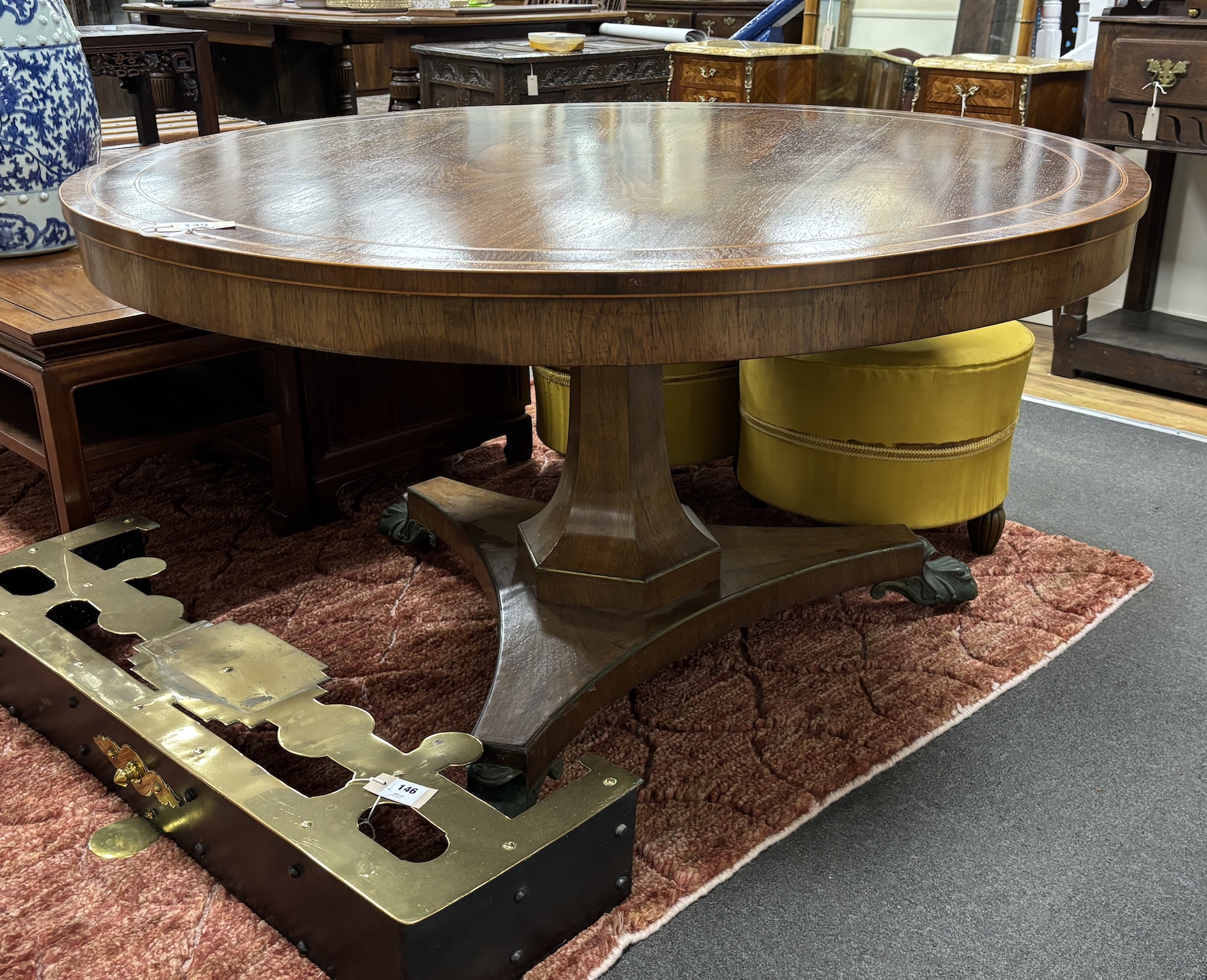 A Regency circular banded rosewood tilt top breakfast table on ormolu claw feet, diameter 132cm, height 73cm